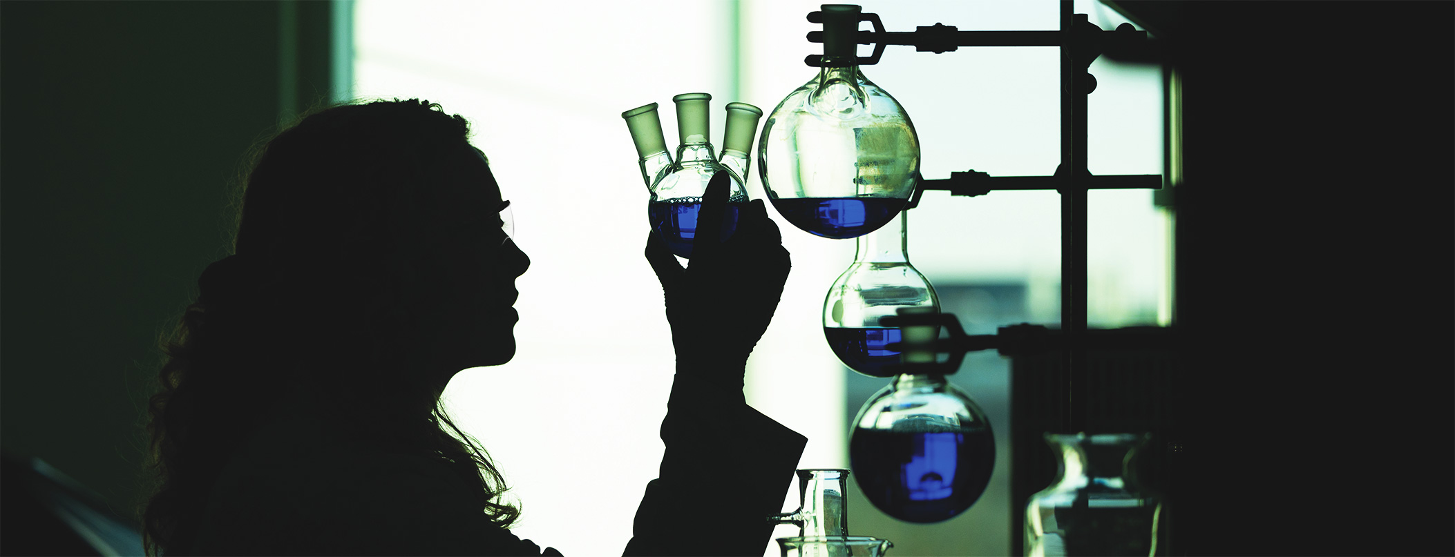 student holding flask in lab setting